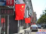 店鋪門(mén)前旗飄揚(yáng) 營(yíng)口人愛(ài)國(guó)熱情高漲